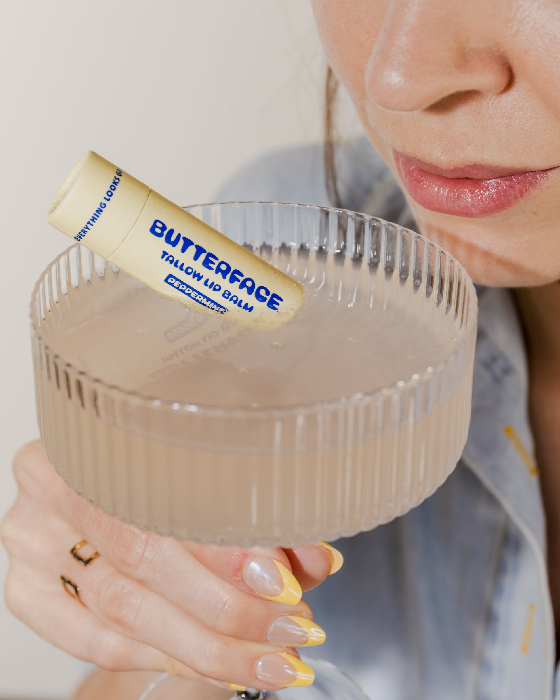 tallow lip balm named Butterface in a cocktail glass being sipped